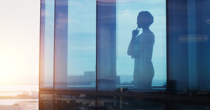 Silhouette, woman or thinking at window for business, reflection or idea for company growth in office. Female CEO, brainstorming or plan in workplace for leadership inspiration in future investment.