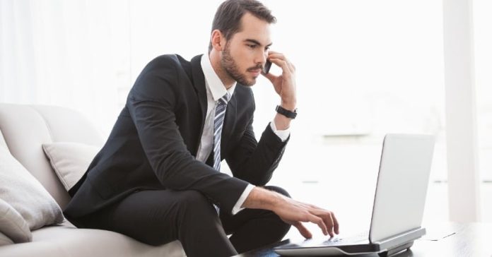 Businessman working on his couch at home in the living room